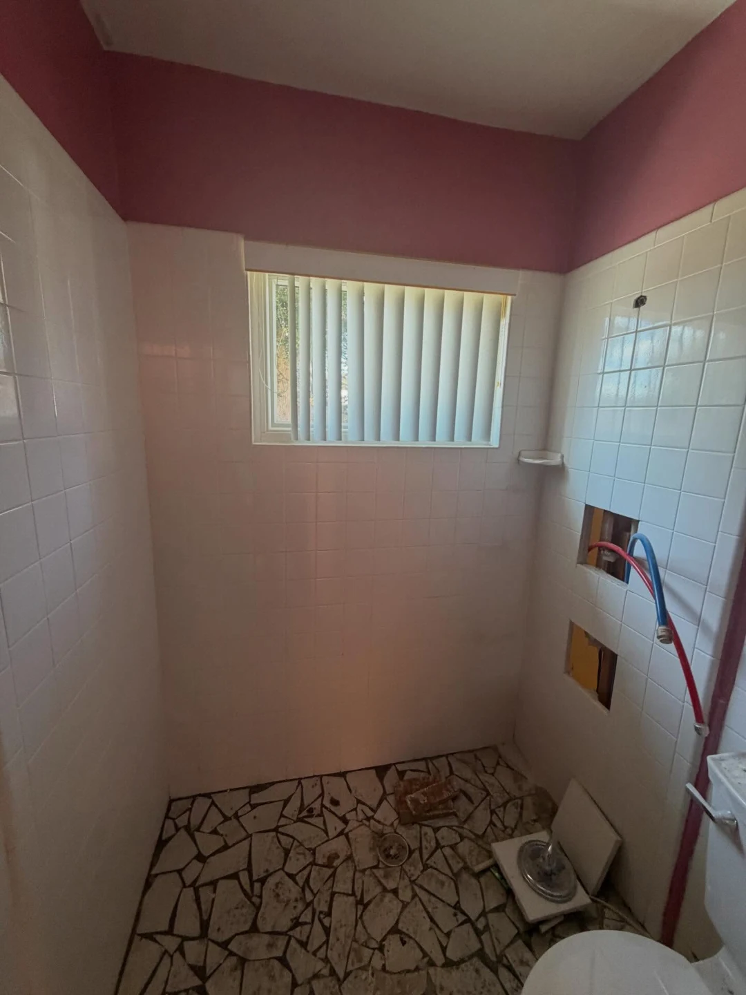 The same bathroom before, with white tile and pink walls